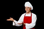 Smiling Male Chef Presenting Something Stock Photo