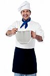 Smiling Male Cook Holding A Saucepan And Ladle Stock Photo