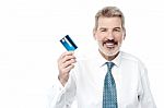 Smiling Male Executive Showing Debit Card Stock Photo