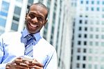 Smiling Male Executive Using His Mobile Phone Stock Photo