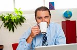 Smiling Male Manager Enjoying Hot Coffee Stock Photo