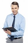 Smiling Male Secretary Holding A Clipboard Stock Photo