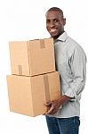 Smiling Man Holding Cardboard Boxes Stock Photo