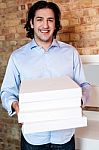 Smiling Man Holding Pizza Boxes Stock Photo