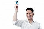 Smiling Man Holding Up His Credit Card Stock Photo