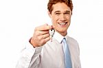 Smiling Man Offering House Key Stock Photo