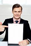 Smiling Man Pointing Towards Blank Clipboard Stock Photo