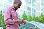 Smiling Man Using His Cell Phone Stock Photo