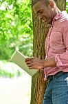 Smiling Man Using Tablet Pc In The Park Stock Photo