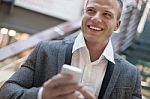 Smiling Men With Smartphone In Business Building Stock Photo