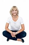 Smiling Middle Aged Woman Sitting On The Floor Stock Photo