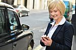 Smiling Middle Aged Woman Using Cell Phone Stock Photo