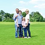 Smiling Parents With Their Kids In The Park Stock Photo