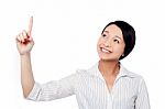 Smiling Pretty Girl Looking And Pointing Upwards Stock Photo