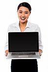 Smiling Saleswoman Presenting Brand New Laptop Stock Photo