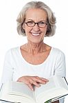 Smiling Senior Woman Reading A Book Stock Photo