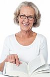 Smiling Senior Woman Reading A Book Stock Photo