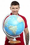 Smiling Tattoo Guy Showing Globe Stock Photo