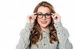 Smiling Woman Adjusting Her Spectacles Stock Photo