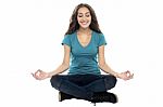 Smiling Woman Meditating In Lotus Position Stock Photo