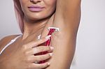 Smiling Woman With Pink Hair Shaving Armpit With Pink Shaver Stock Photo