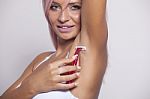 Smiling Woman With Pink Hair Shaving Armpit With Pink Shaver Stock Photo