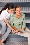 Smiling Women Sitting Steps Using Digital Tablet Stock Photo