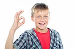 Smiling young boy showing ok sign Stock Photo