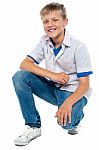 Smiling Young Boy Squatting Down Stock Photo