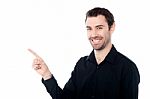 Smiling Young Guy Pointing At Something Stock Photo