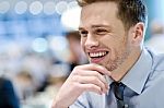 Smiling Young Man Sitting In A Outdoor Cafe Stock Photo