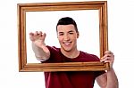 Smiling Young Man With Picture Frame Stock Photo