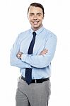 Smiling Young Team Leader Keeping His Arms Folded Stock Photo