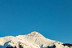 Snowy Mountain Tops In The Blue Sky Sun Stock Photo