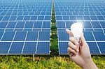 Solar Energy Panels And Light Bulb In Hand Stock Photo