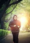 Sport Healthy Man Wearing Hood Jacket Running In Green Park Stock Photo