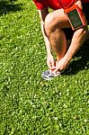 Sportsman Tying Sports Shoes On Grass Stock Photo