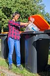 Standing Dutch Woman Dropping Plastic Waste In Trash Bin Stock Photo