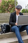 Student Working On His Laptop With An Irish Cap Stock Photo