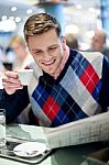 Stylish Man Reading Newspaper At Outdoor Cafe Stock Photo