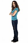 Stylish Woman Standing Sideways With Arms Crossed Stock Photo