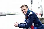 Stylish Young Man Beside River Railing Stock Photo