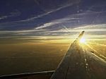 Sun Set On Horizon Cloud Sky  Through Airplane Wing Stock Photo