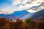 Sunlight Breaking Through The Clouds Over A Mountain Stock Photo