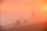 Sunrise Over Mountain Field. Haystacks In Misty Autumn Morning H Stock Photo