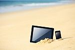 Tablet And Smartphone On The Beach Stock Photo