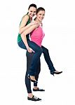 Teenage Girl Piggybacks Her Friend Stock Photo