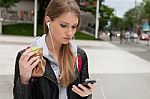 Teenager Eating Cake Looking In Phone Stock Photo