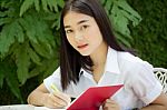 Thai Adult Student University Beautiful Girl Reading Red Book Stock Photo