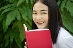 Thai Adult Student University Beautiful Girl Reading Red Book Stock Photo